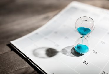 Hour glass on calendar concept for time slipping away for important appointment date, schedule and deadline